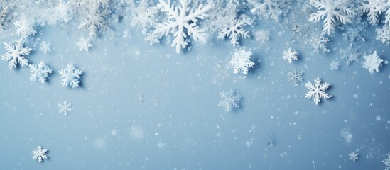 Christmas-themed composition with white snowflakes on a snowy background. Symbolic of the holiday season and new year. Flat lay, top view, room for text.