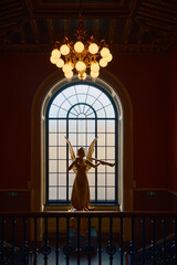 Statue in a museum with a chandelier 
