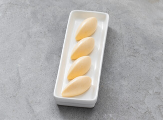 Vegan Tangerine cream dessert quenelle, on a serving plate. Close up