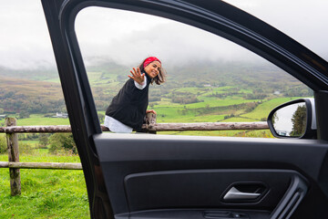 Latin woman photographed from the window of her rental vehicle while sitting and enjoying a break...