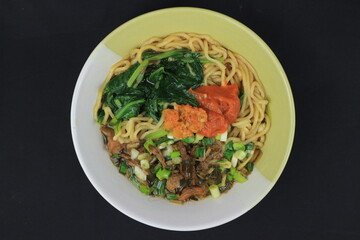 Mie Ayam or Chicken noodle, Popular Indonesian Street Food served in a bowl with sauce and chili sauce