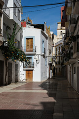 Fototapeta na wymiar Romantic backstreet, side street and alleys in historic old town of Ibiza Stadt, Balearic Island with historic Mediterranean style architecture facades, a landmark sightseeing tourist spot in downtown