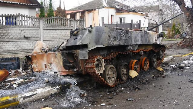 Destroyed russian tank on the street near civilian houses in Bucha, Ukraine. War Combats in early spring of 2022.