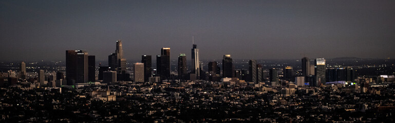 Bustling urban skyline featuring high-rise buildings, illuminated by the dusk light, Los Angeles