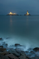 Thiruvalluvar Statue of kanyakumari lighthouse on the coast in the milky sea water hitting the rocks with light