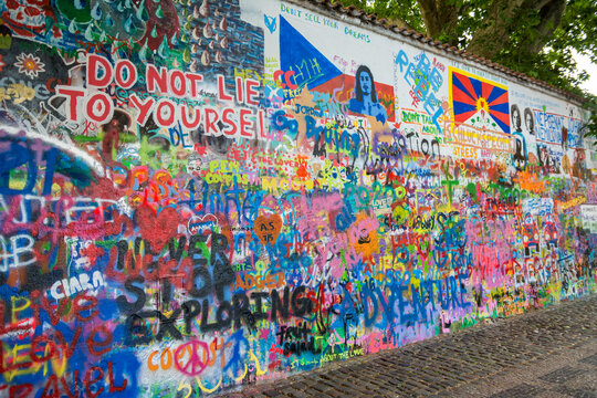 PRAGUE, CZECH REPUBLIC, JULY 7, 2016: People filling the Lennon Wall; located in a secluded square across from the French Embassy, the wall had been decorated by love poems and short messages.