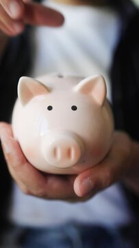 Hand putting coin in pig moneybox for saving money. Financial and invest concept