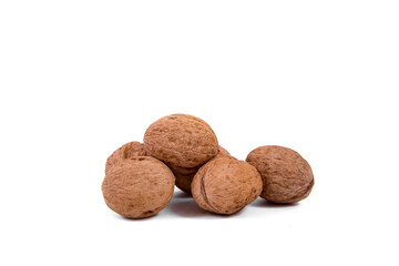 Scattered whole walnuts lie on a white background. Backgrounds and textures. Isolate.