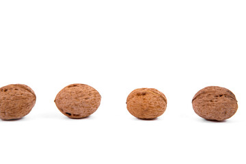 Scattered whole walnuts lie on a white background. Backgrounds and textures. Isolate.