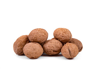 Scattered whole walnuts lie on a white background. Backgrounds and textures. Isolate.