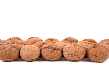 Scattered whole walnuts lie on a white background. Backgrounds and textures. Isolate.