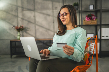 Pregnant woman doing online shopping hold credit card sit at home