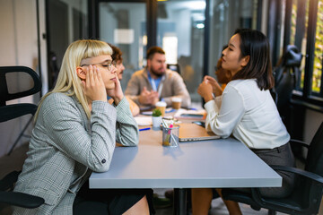 Young business woman having headache in the office while having a meeting