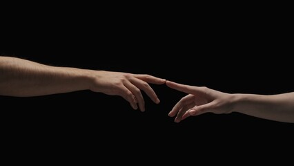 Portrait of models hands isolated on black background. Man and woman naked hands lending to each other and touch fingers.