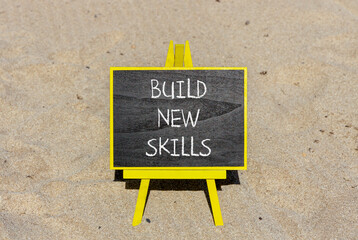 Build new skills symbol. Concept word Build new skills on beautiful black chalk blackboard. Sand beach. Beautiful sand beach background. Business, education build new skills concept. Copy space.