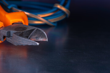 Cutting pliers and electrical cable close-up, electric workshop tool