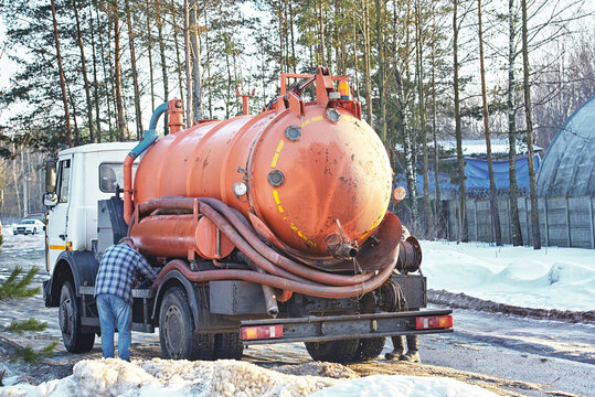 Sewer cleaning truck, sewage cleanup service. Truck with cistern and pump hose. Liquid drain machine. Plumbers work. Septic cleaning vacuum service, maintenance suburban countryside home