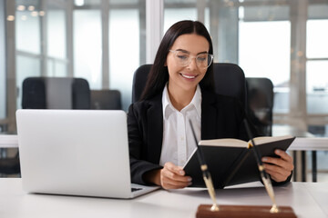 Smiling lawyer working at table in office