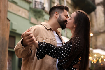 Lovely couple kissing and dancing together on city street