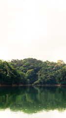 Reflejo de montañas y arboles en el agua de una represa en Colombia