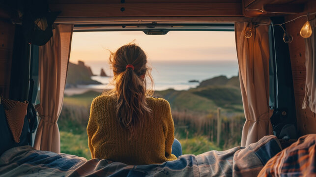 A woman looking at the view from her campervan