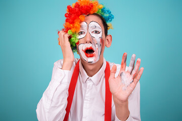 A screaming clown. Greased makeup. Blue background. A rude, angry, offended man.