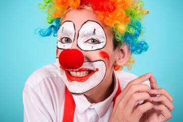 A screaming clown. Greased makeup. Blue background. A rude, angry, offended man.