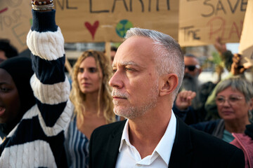 Close up Angry and rebellious mature man protesting with megaphone at demonstration at climate...