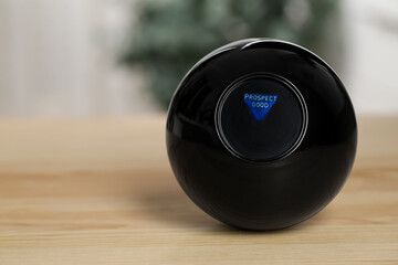 Magic eight ball with prediction Prospect Good on wooden table, closeup. Space for text