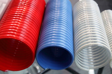 Modern colorful plastic spiral hoses. Helical composite wire reinforced pipe production