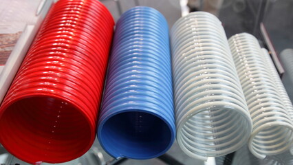 Modern red blue white colored polymer spiral fiberglass reinforced pipes closeup