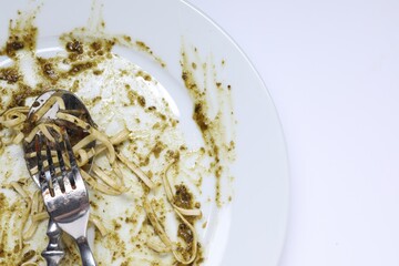 Dirty plate and cutlery on white background, top view