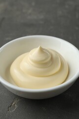 Fresh mayonnaise sauce in bowl on grey table, closeup