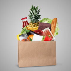 Paper bag with different products and receipt on grey background