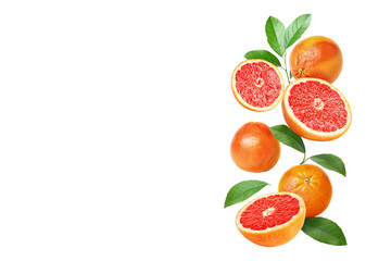 Fresh grapefruits and green leaves falling on white background