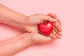 Woman holding heart shape in hand, healthcare