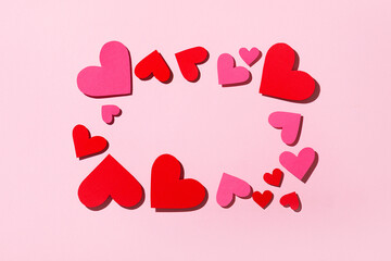 Frame for text made of pink and red hearts on a pink background. Love concept. Valentine's Day. Top view. Space for text.
