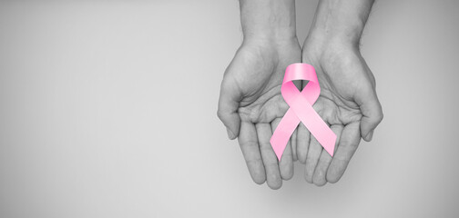 Hand holding pink breast cancer awareness ribbon