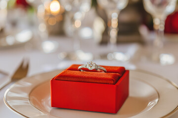 Engagement ring in red box on served table