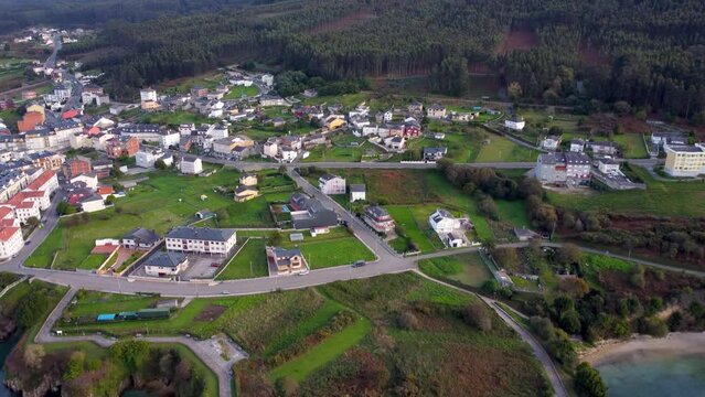 Beautiful aerial landscape in North of Spain, Galicia. Typically, costal small village, surrounded by forest. Small bay of water. O Vicedo village. Drone forward. Travel destination in north of Spain