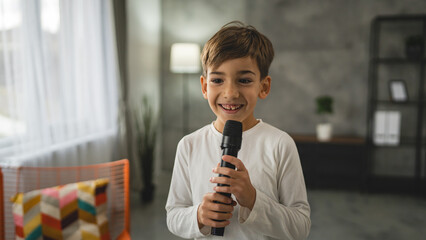 boy seven years old child hold microphone at home happy smile sing