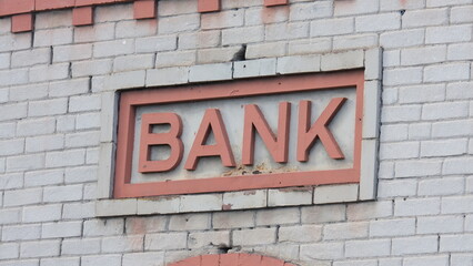 Close up of vintage architecture with old cream bricks and a retro, vintage sign with the word bank