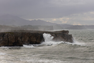 Bufones de Pria in Asturias coast on a cloudy day with rough seas and wave spray