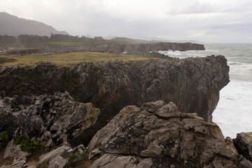 Fototapeta na wymiar Landscape of Bufones de Pria in Asturias coast on a cloudy day with rough seas and wave spray