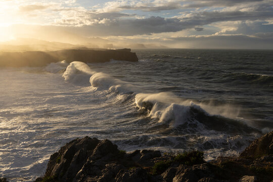 Splashing water from crashing waves on spanish coastline in the north of Spain in Asturias at Bufones de Pria part of Camino de Santiago path