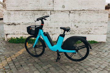 Obraz na płótnie Canvas Bike Rent e-bicycle in city Street. Eco-friendly mode of transport