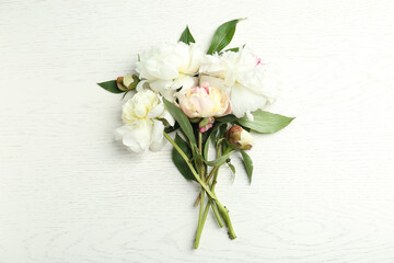 Beautiful peonies on white wooden table, flat lay