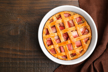Baking dish with tasty apple pie on wooden table, top view. Space for text