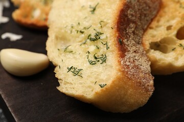 Tasty baguette with garlic and dill on table, closeup