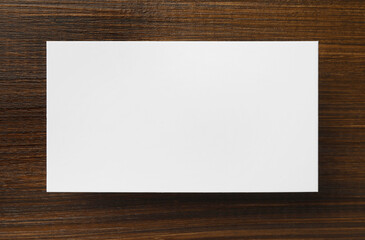 One blank business card on wooden table, top view. Mockup for design